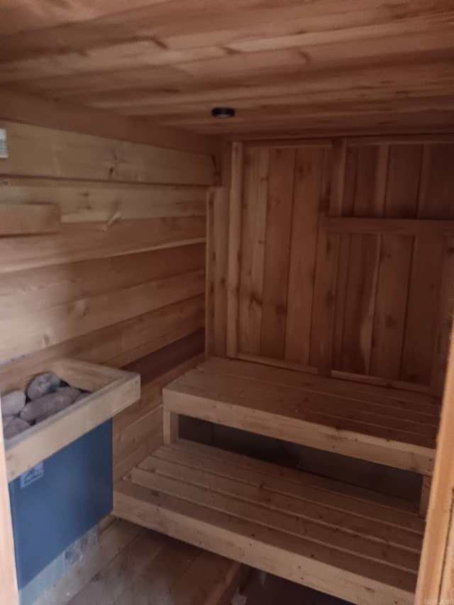 view of sauna / steam room with wooden walls, wooden ceiling, and wood-type flooring