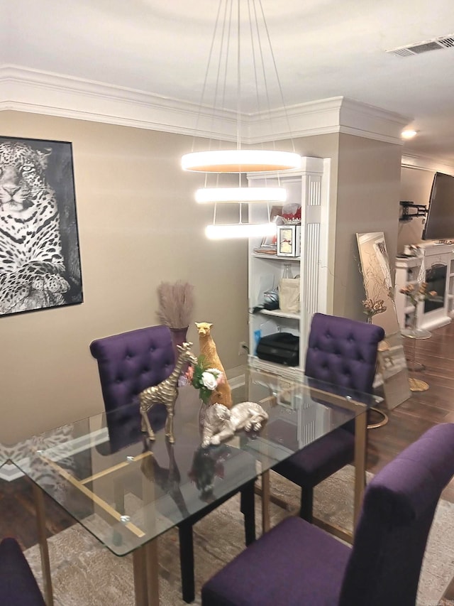 dining space with wood-type flooring and ornamental molding