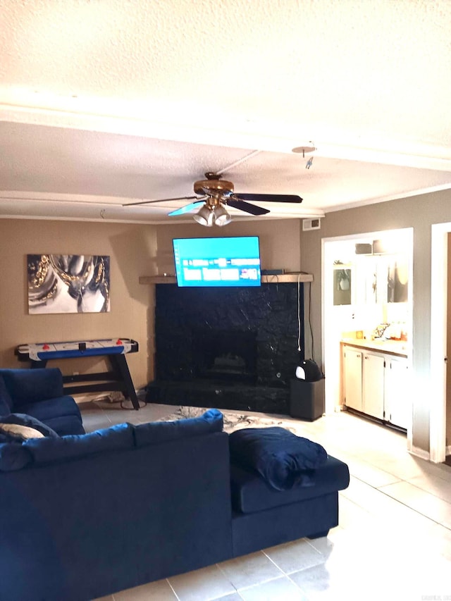 living room featuring ceiling fan, light tile patterned floors, and a textured ceiling