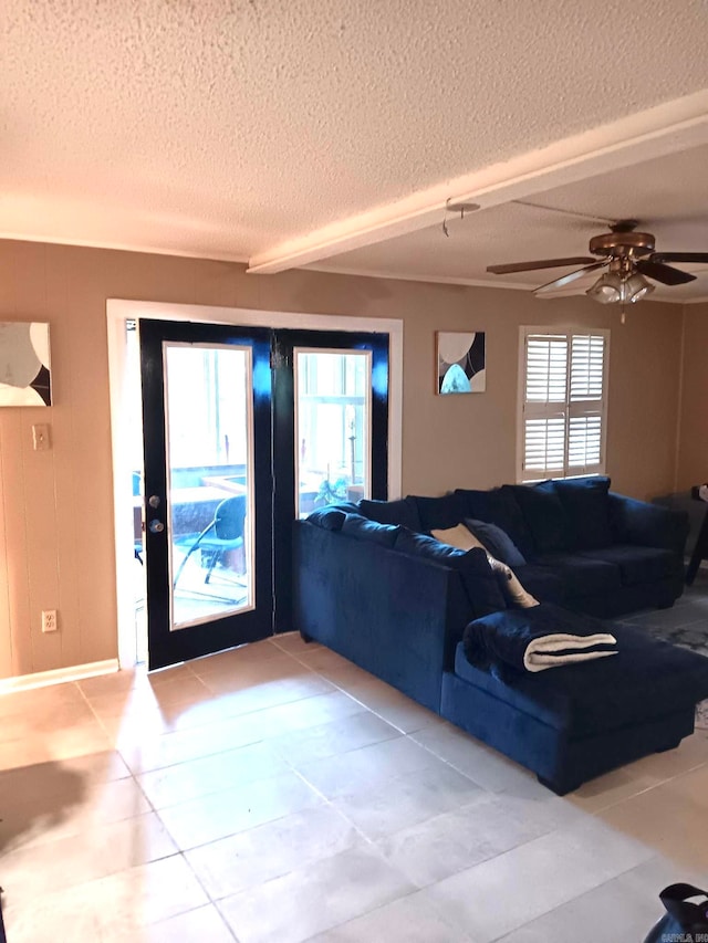 living room with ceiling fan, a textured ceiling, tile patterned flooring, and a wealth of natural light