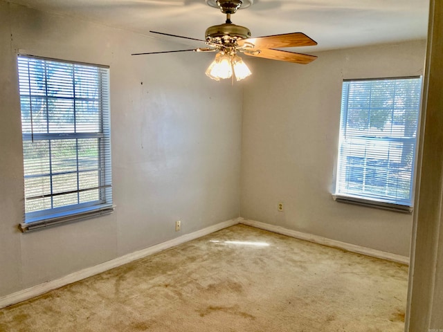 carpeted spare room with a wealth of natural light and ceiling fan