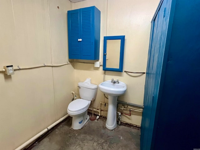 bathroom featuring sink, toilet, and concrete floors