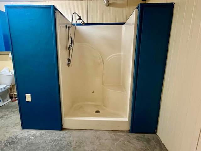 bathroom with walk in shower, toilet, and concrete floors