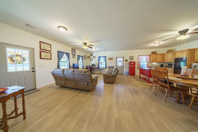 living room featuring light wood-type flooring and ceiling fan