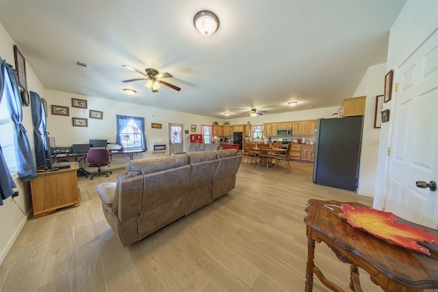 living room featuring ceiling fan and light hardwood / wood-style floors