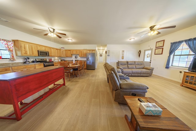 living room with light wood-type flooring and ceiling fan