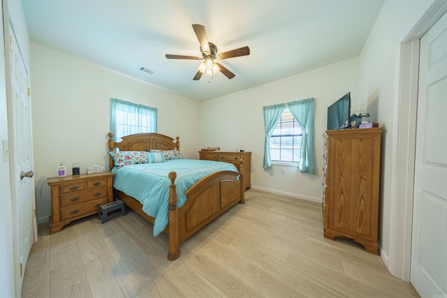 bedroom featuring light hardwood / wood-style floors, multiple windows, and ceiling fan