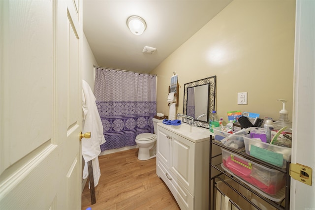 bathroom featuring wood-type flooring, vanity, and toilet