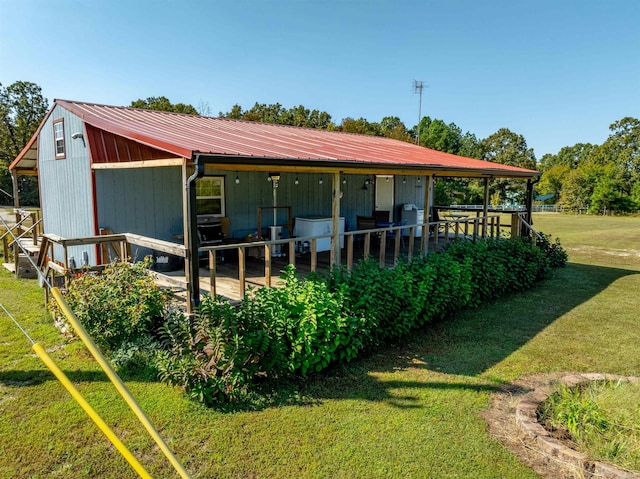 back of property featuring a yard and an outdoor structure