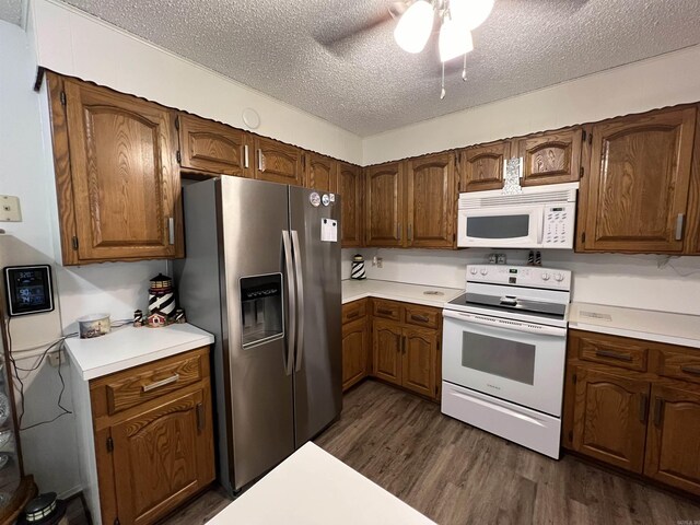 kitchen featuring ceiling fan, white appliances, dark hardwood / wood-style floors, and a textured ceiling