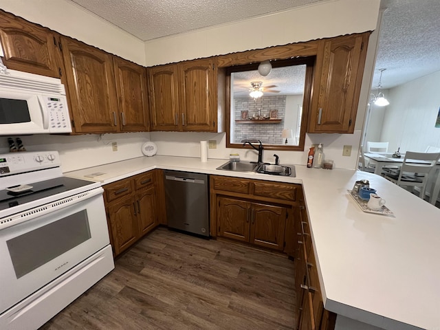 kitchen with white appliances, sink, dark hardwood / wood-style floors, and a textured ceiling