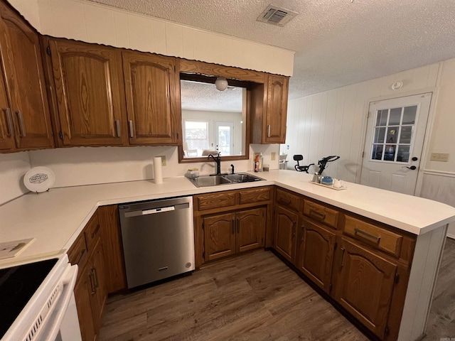 kitchen featuring sink, kitchen peninsula, stainless steel dishwasher, a textured ceiling, and dark hardwood / wood-style flooring