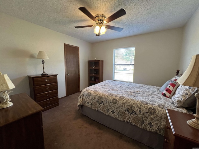 bedroom featuring dark carpet, a textured ceiling, and ceiling fan