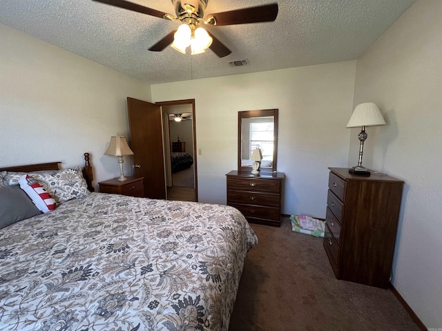 bedroom featuring dark colored carpet, a textured ceiling, and ceiling fan