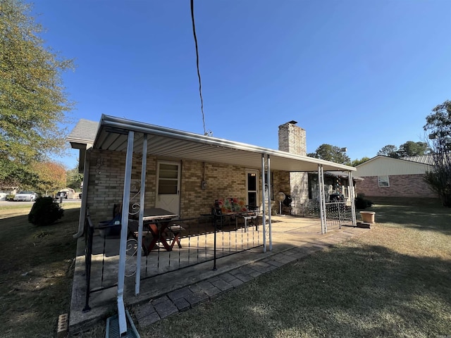 back of house with a yard and a patio