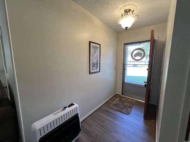 entryway with heating unit, dark hardwood / wood-style floors, and a textured ceiling