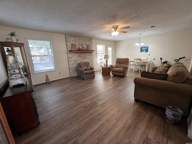 living room featuring a textured ceiling, plenty of natural light, and dark hardwood / wood-style flooring