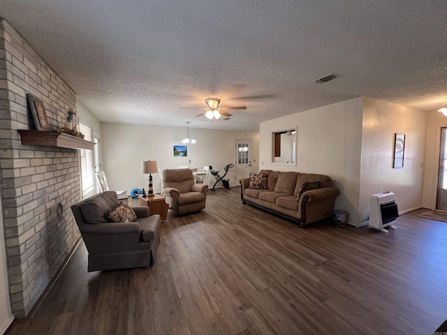 living room featuring a textured ceiling, heating unit, and dark wood-type flooring