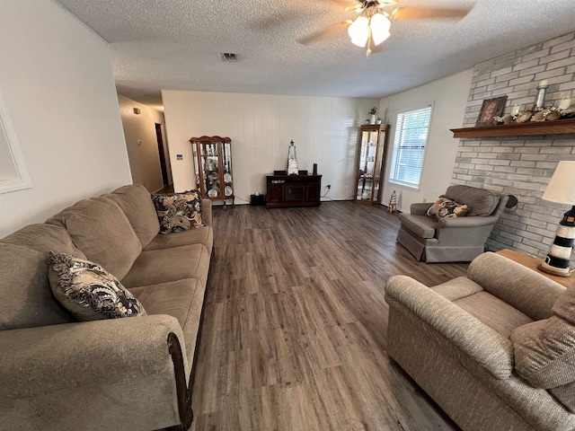 living room with ceiling fan, dark hardwood / wood-style floors, and a textured ceiling