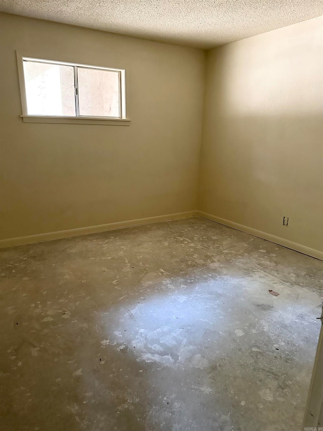 spare room with concrete floors and a textured ceiling