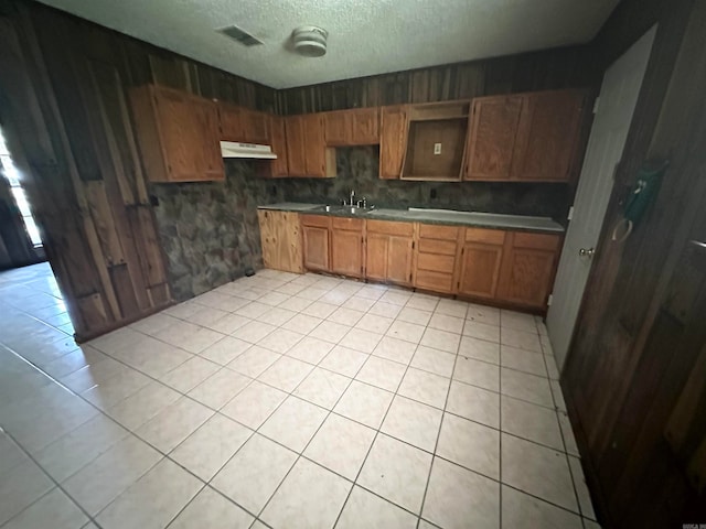 kitchen featuring light tile patterned flooring, a textured ceiling, sink, and backsplash