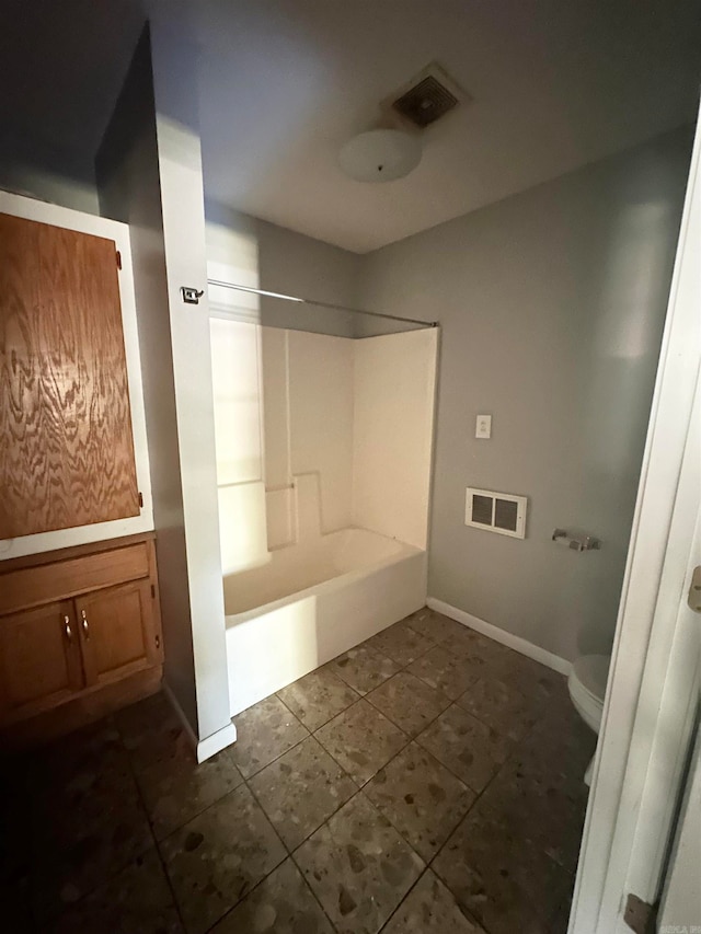 bathroom featuring tub / shower combination, tile patterned flooring, and toilet