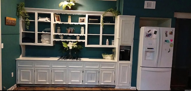 bar with white refrigerator with ice dispenser and white cabinets