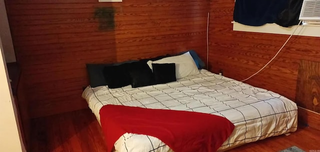 bedroom with wood walls and hardwood / wood-style floors