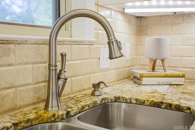 interior details featuring light stone counters and sink