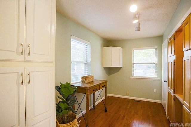 laundry area with a textured ceiling and dark hardwood / wood-style flooring