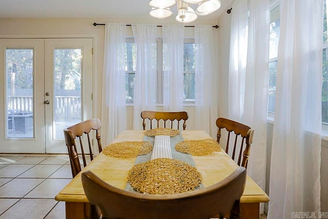 tiled dining area with french doors and a notable chandelier