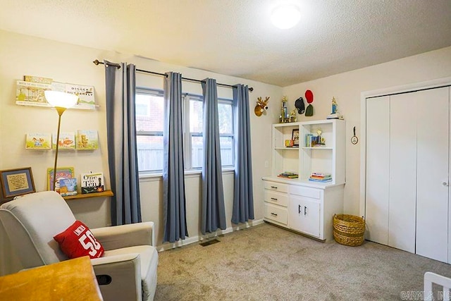 living area with a textured ceiling and light colored carpet