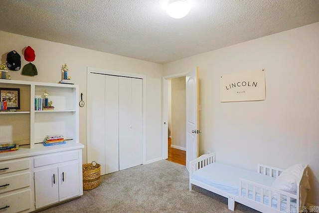 carpeted bedroom with a closet and a textured ceiling