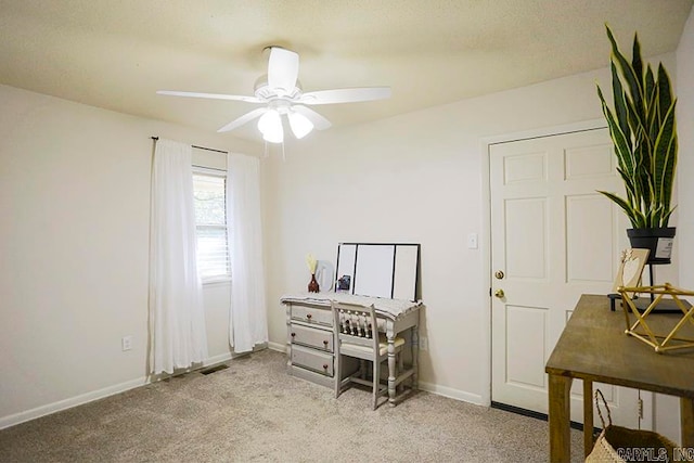 carpeted home office featuring ceiling fan