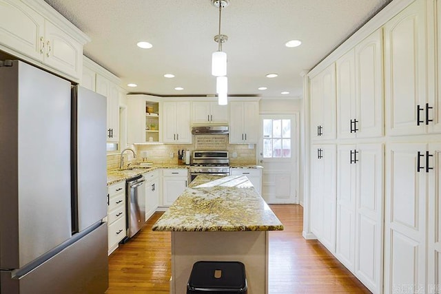 kitchen with stainless steel appliances, pendant lighting, hardwood / wood-style flooring, and a center island