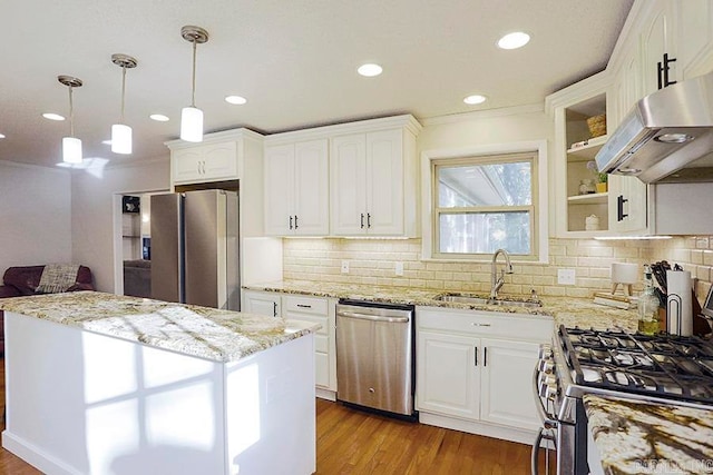 kitchen featuring light stone counters, sink, pendant lighting, white cabinetry, and appliances with stainless steel finishes