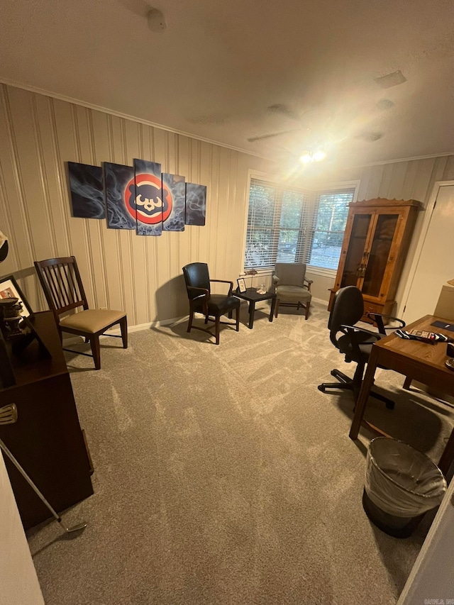 sitting room with ornamental molding and carpet flooring