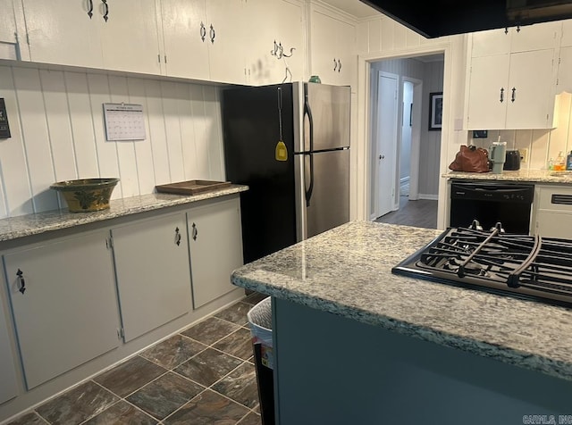 kitchen featuring light stone countertops, black dishwasher, white cabinets, and stainless steel fridge