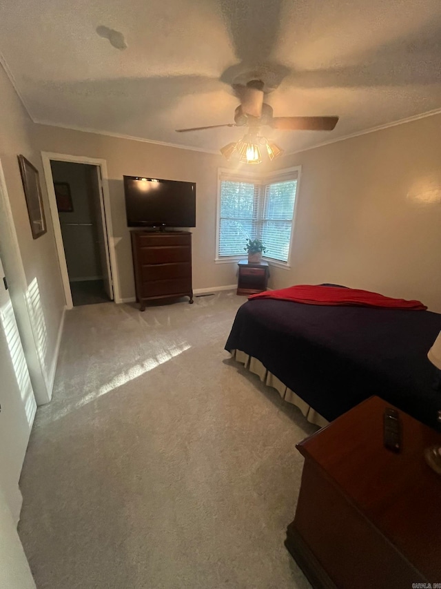 carpeted bedroom featuring ceiling fan, a textured ceiling, and crown molding