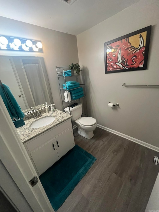 bathroom featuring vanity, toilet, and hardwood / wood-style flooring