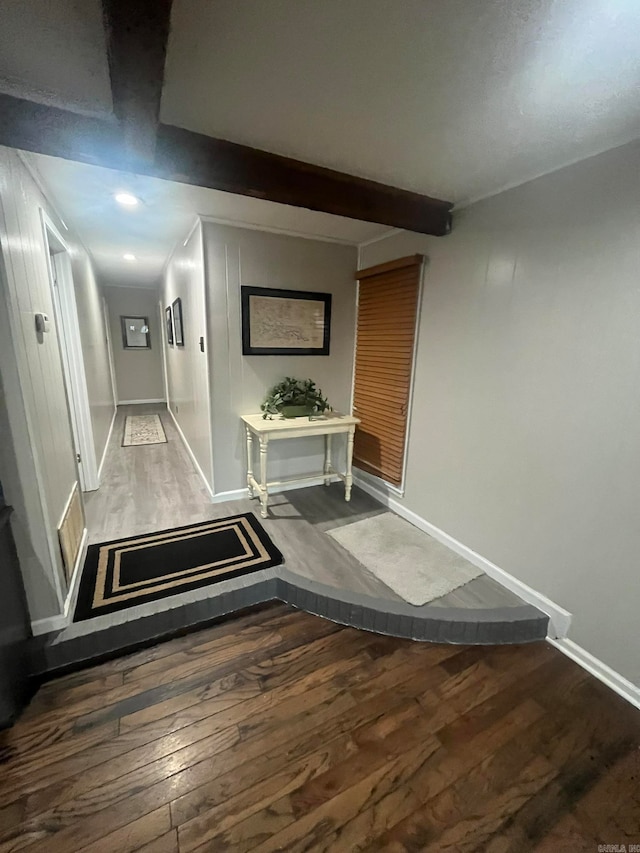 hallway featuring beamed ceiling and dark hardwood / wood-style floors