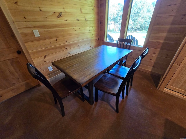 carpeted dining room with wooden walls