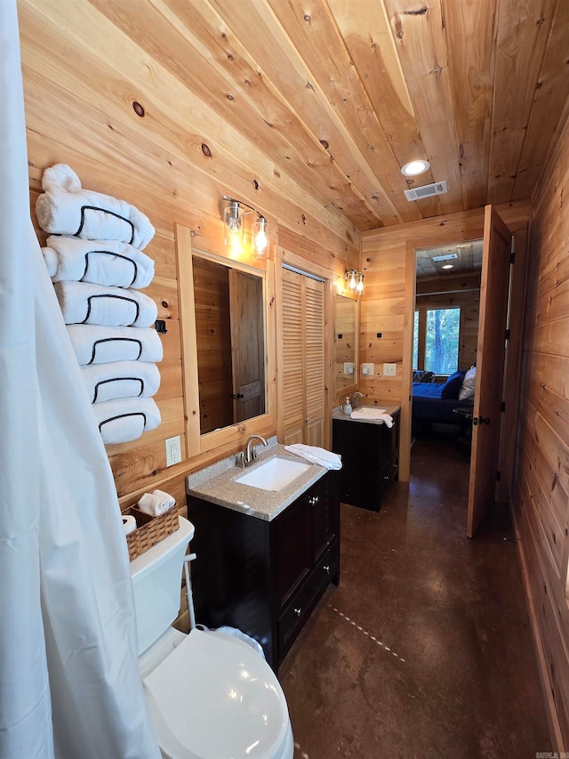 bathroom featuring vanity, wood ceiling, wooden walls, concrete flooring, and toilet