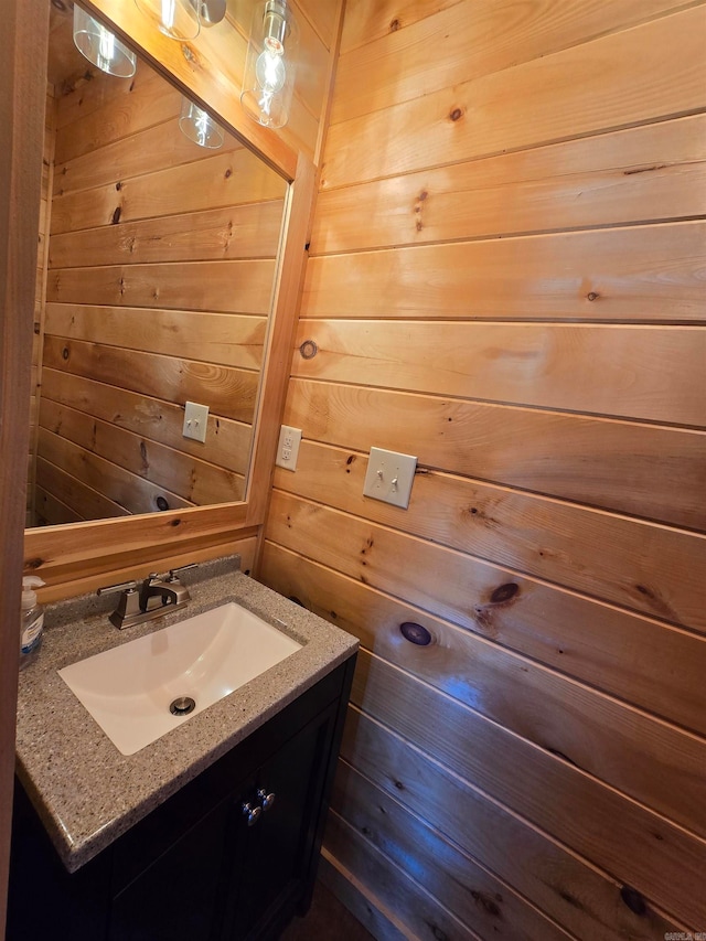 bathroom featuring vanity and wood walls