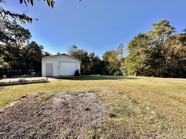 view of yard with a garage and an outbuilding