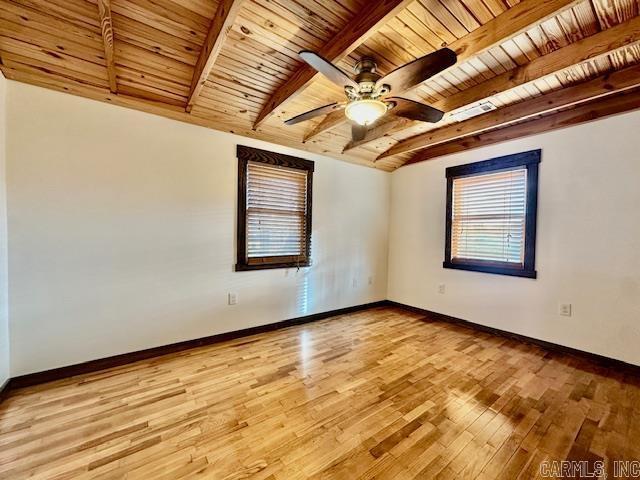 empty room featuring beamed ceiling, light hardwood / wood-style flooring, ceiling fan, and wooden ceiling