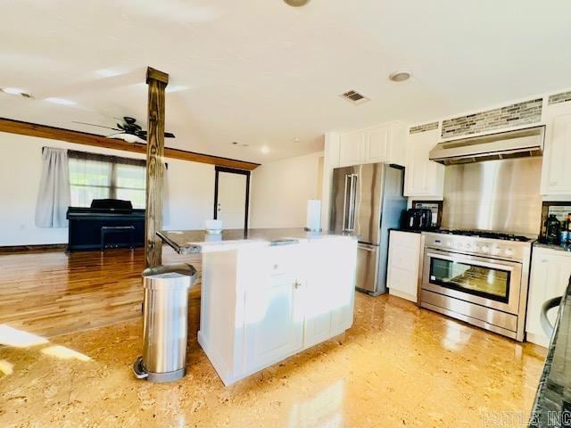 kitchen featuring backsplash, white cabinets, ceiling fan, range hood, and appliances with stainless steel finishes