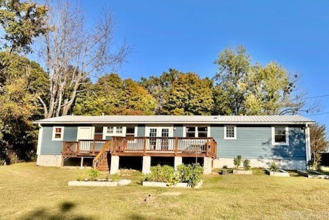 rear view of property featuring a lawn and a deck