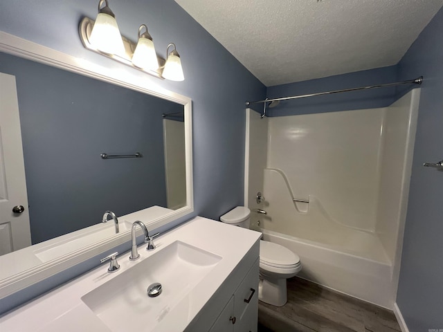 full bathroom with shower / bath combination, toilet, wood-type flooring, vanity, and a textured ceiling