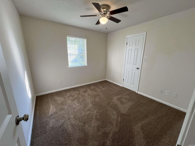 carpeted empty room featuring ceiling fan and a textured ceiling